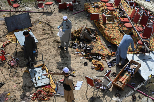 Petugas polisi memeriksa lokasi ledakan bom bunuh diri di distrik Bajaur, provinsi Khyber-Pakhtunkhwa, Pakistan, Senin (31/7/2023). Foto: Abdul MAJEED / AFP