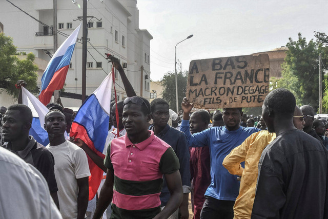 Para pengunjuk rasa mengibarkan bendera Niger dan Rusia saat mereka berkumpul selama rapat umum untuk mendukung junta Niger di Niamey pada 30 Juli 2023. Foto: AFP