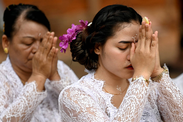 Sejumlah umat Hindu melakukan persembahyangan Hari Raya Galungan di Denpasar, Bali, Rabu (2/8/2023). Foto: Sonny Tumbelaka/AFP