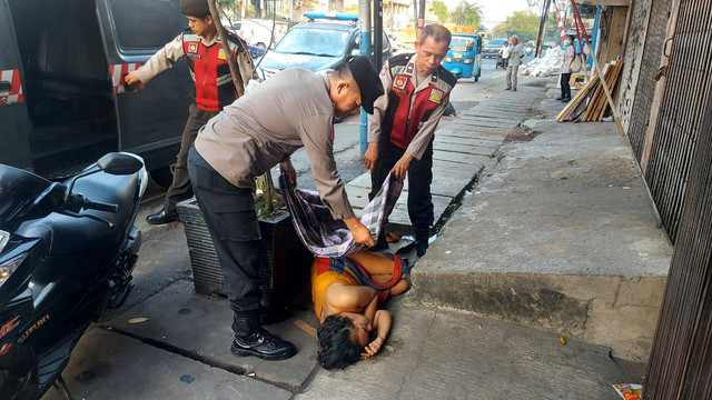 Polisi evakuasi wanita diduga mabuk tergeletak di Jalan Perniagaan Raya, Tambora, Kamis (3/8/2023). Foto: Dok. Istimewa
