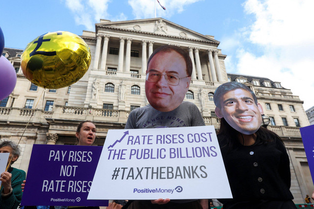 Demonstran mengenakan topeng yang menggambarkan Gubernur Bank of England Andrew Bailey dan Perdana Menteri Inggris Rishi Sunak dalam protes terhadap kenaikan suku bunga di luar Bank of England di London, Inggris, Kamis (3/8/2023).  Foto: Susannah Ireland/REUTERS