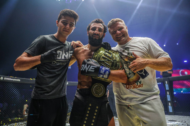 Anatoly Malykhin (kanan) merayakan kemenangan Chingiz Allazov (tengah). Foto: ONE Championship