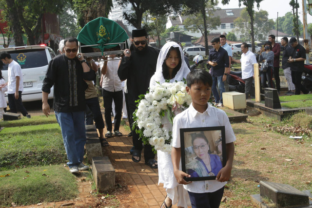 Vokalis band Cokelat, Kikan, bersama keluarga saat mengantarkan jenazah ibunda di TPU Jeruk Purut, Jakarta, Rabu, (9/8/2023). Foto: Agus Apriyanto