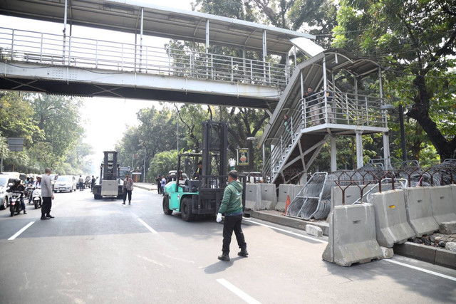 Petugas menggunakan forklift memasang pembatas beton untuk menutup jalan Medan Merdeka Barat jelang demo buruh di kawasan Patung Kuda, Jakarta Pusat, Kamis (10/8/2023). Foto: Fitra Andrianto/kumparan