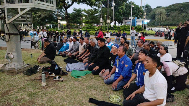 Massa buruh salat magrib berjemaah di kawasan Patung Kuda, Jakarta Pusat, Kamis (10/8).  Foto: Jonathan Devin/kumparan