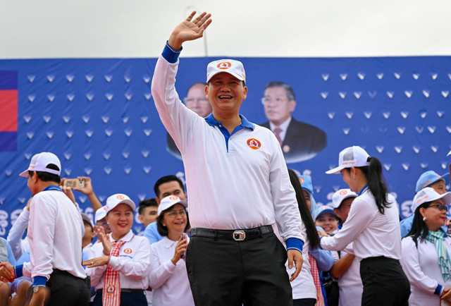 Komandan Tentara Kerajaan Kamboja dan putra sulung Perdana Menteri Hun Sen, Hun Manet menyapa para pendukungnya saat kampanye di Phnom Penh pada 21 Juli 2023. Foto: Tang Chhin Sothy / AFP