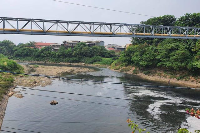 Aliran Kali Bekasi dalam kondisi berwarna hitam pekat dan berbusa imbas terkena limbah.  Foto: kumparan