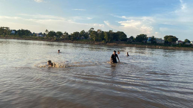 Warga mandi dan bersantai sore di pasir timbul Sungai Melawi, Kelurahan Sengkuang. Foto: Yusrizal/Hi!Pontianak