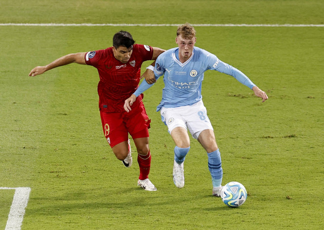 Duel Marcos Acuna dan Cole Palmer Man City vs Sevilla dalam laga Piala Super Eropa (UEFA) di Stadion Georgios Karaiskakis, Yunani, pada (17/8/2023) dini hari WIB. Foto: REUTERS/Louiza Vradi