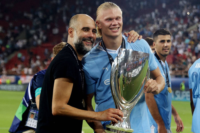Pemain Manchester City Erling Braut Haaland dan manajer Pep Guardiola berselebrasi dengan trofi setelah memenangkan Piala Super UEFA, di Stadion Georgios Karaiskakis, Athena, Yunani, Rabu (16/8/2023). Foto: Alkis Konstantinidis/REUTERS