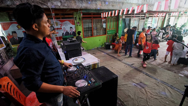 Aksi  heboh Disk Jockey yang mengiringi kegiatan lomba perayaan HUT RI di blok sembilan warga rusun Palembang, Kamis (17/8) Foto: ary priyanto/urban id