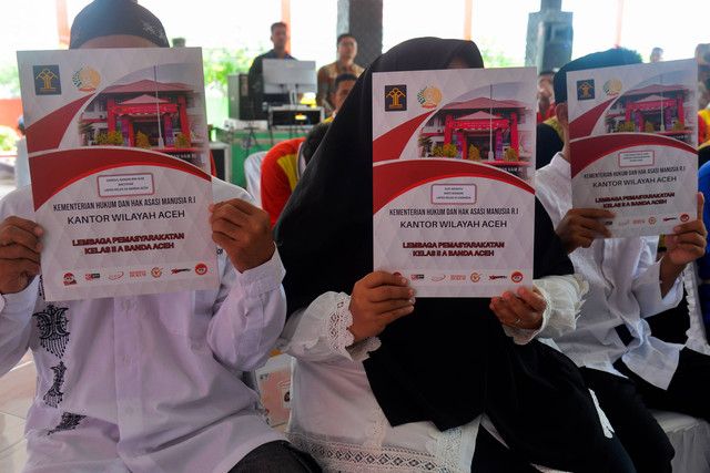 Tiga warga binaan memperoleh surat remisi seusai mengikuti upacara peringatan HUT ke-78 Kemerdekaan RI di Lapas Kelas II A, Banda Aceh, Aceh, Kamis (17/8/2023). Foto: Ampelsa/Antara Foto