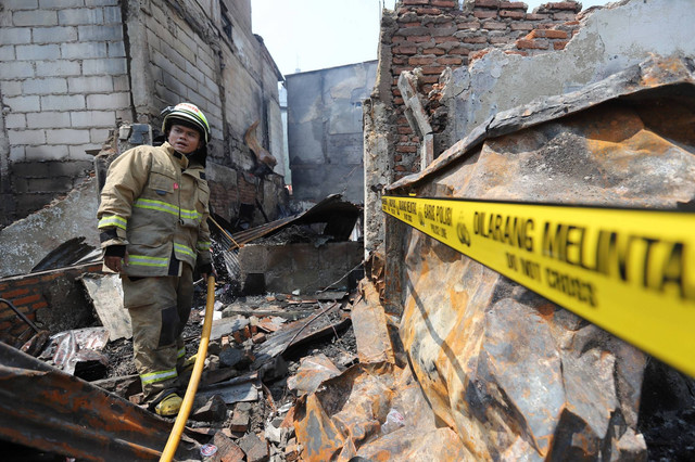 Petugas pemadam kebakaran melakukan pendinginan di lokasi kebakaran permukiman padat penduduk di Gang Kober, Petojo Selatan, Gambir, Jakarta Pusat, Kamis (24/8/2023). Foto: Dicky Adam Sidiq/kumparan