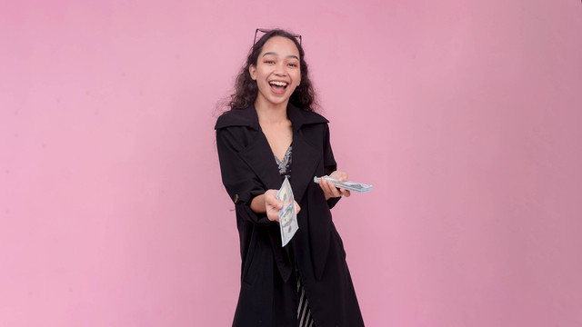 Ilustrasi perempuan keluarkan uang secara impulsif. Foto: MDV Edwards/Shutterstock