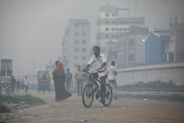 Warga Dhaka, Bangladesh beraktivitas didalam kepungan asap polusi. Foto: REUTERS/Mohammad Ponir Hossain