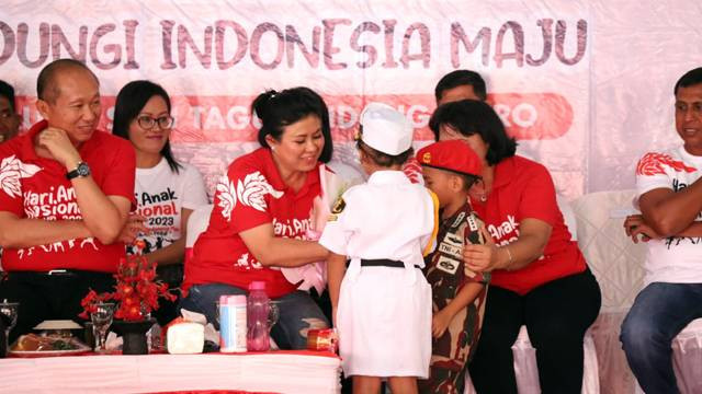 Bupati Kabupaten Sitaro, Evangelian Sasingen menerima buket bunga yang diserahkan siswa di Pulau Tagulandang pada perayaan Hari Anak Nasional.