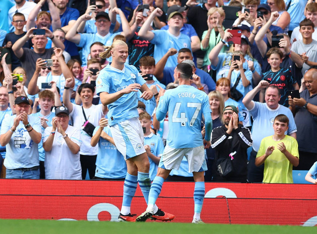 Erling Braut Haaland dari Manchester City merayakan mencetak gol keempat mereka bersama Phil Foden saat pertandingan di Stadion Etihad, Manchester, Inggris. Foto: Molly Darlington/Reuters