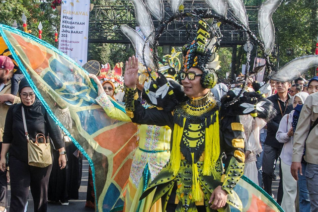 Gubernur Jawa Barat Ridwan Kamil (kanan) dengan menggunakan kostum menyapa warga saat mengikuti karnaval budaya West Java Festival di Bandung, Jawa Barat, Minggu (3/9/2023).  Foto: Novrian Arbi/ANTARA FOTO