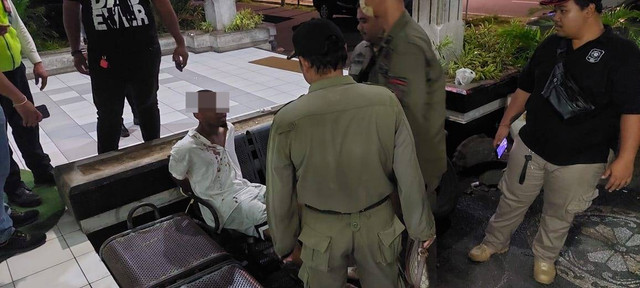 Petugas mengamankan WN AS Pamer Kelamin di Bandara Ngurah Rai, Bali. Foto: Dok. Polres Bandara Ngurah Rai