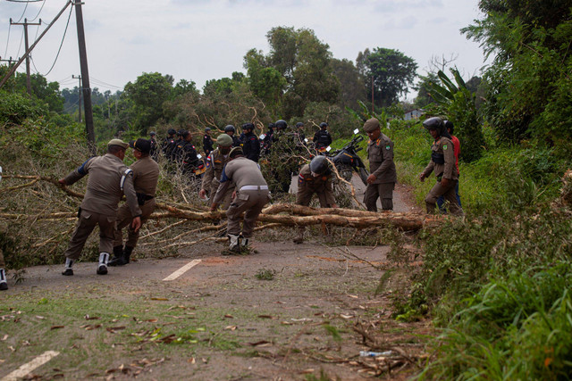Sejumlah petugas yang tergabung dalam Tim Terpadu membersihkan pemblokiran jalan yang dilakukan oleh warga Pulau Rempang, Batam, Kepulauan Riau, Jumat (8/9/2023). Foto: Teguh Prihatna/Antara Foto