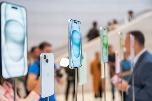 Pengunjung mencoba Apple iPhone 15 baru, dengan pengisi daya USB-C pesanan UE, ditampilkan di antara produk baru lainnya saat acara peluncuran di Apple Park di Cupertino, California, Selasa (12/9/2023). Foto: Nic Coury / AFP