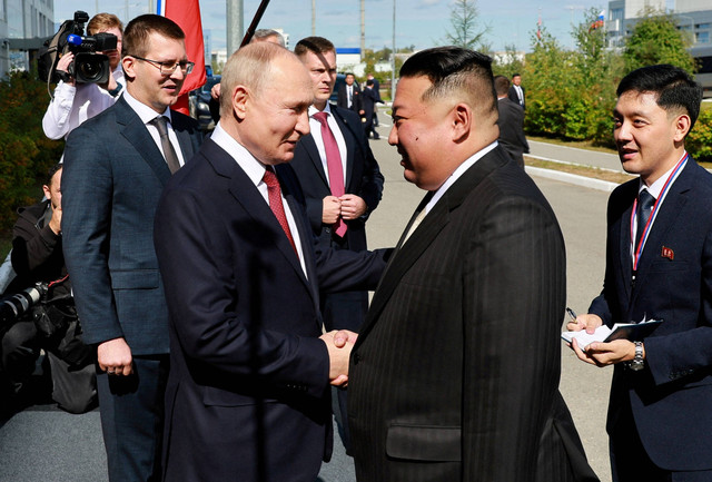 Presiden Rusia Vladimir Putin berjabat tangan dengan pemimpin Korea Utara Kim Jong Un di Vostochny Cosmodrome di Rusia, Rabu (13/9/2023). Foto: Sputnik/Vladimir Smirnov/Reuters