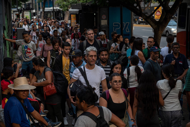 Sejumlah orang antre di halte bus imbas pemadaman listrik di stasiun metro di Caracas, Venezuela pada Rabu (13/9/2023). Foto: Miguel ZAMBRANO / AFP