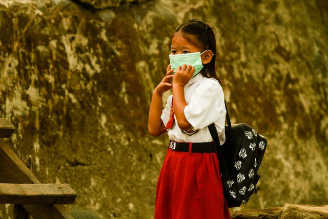 Ilustrasi penggunaan masker saat polusi kabut asap. (foto: Ary Priyanto/Urban Id)