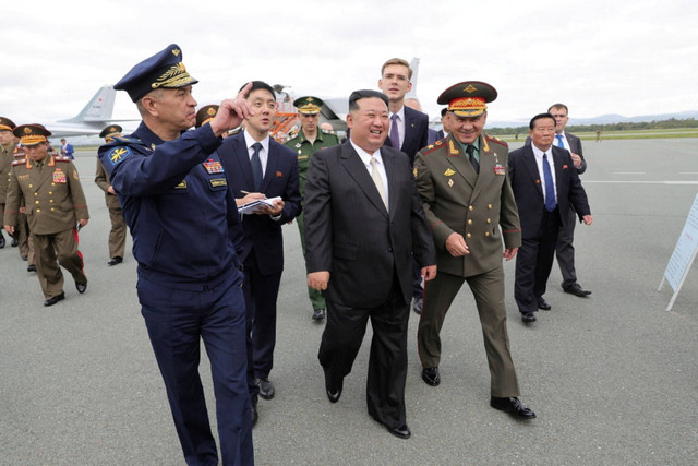 Pemimpin Korea Utara Kim Jong-un dan Menteri Pertahanan Rusia Sergei Shoigu memeriksa pesawat dan rudal militer Rusia yang dipajang di bandar udara Knevichi dekat Vladivostok di wilayah Primorsky, Rusia, Sabtu (16/9/2023). Foto: Kementerian Pertahanan Rusia/Handout via Reuters