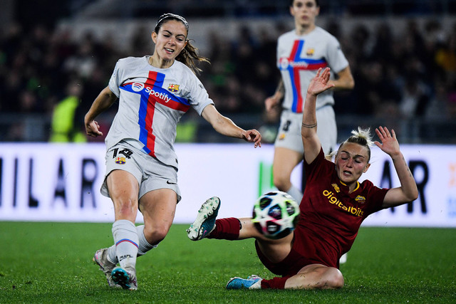Gelandang AS Roma asal Italia Giada Greggi (kanan) mencoba menjegal gelandang Barcelona asal Spanyol Aitana Bonmati pada pertandingan sepak bola leg pertama perempat final Liga Champions Wanita UEFA antara AS Roma dan Barcelona pada 21 Maret 2023. Foto: Filippo Monteforte / AFP