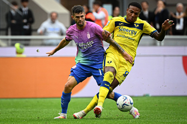 Pemain AC Milan Christian Pulisic beraksi dengan pemain Hellas Verona Michael Folorunsho di stadion San Siro di Milan, Italia, Sabtu (23/9/2023). Foto: Piero Cruciatti/AFP