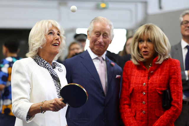 Ratu Inggris Camilla bersiap bermain tenis meja dengan istri Presiden Prancis Brigitte Macron saat berkunjung ke Saint-Denis, Prancis. Foto: HANNAH MCKAY/POOL/AFP
