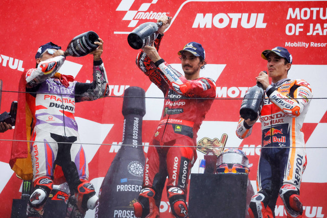 Pembalap Jorge Martin merayakan di podium setelah memenangkan MotoGP, bersama dengan peringkat kedua Francesco Bagnaia dan peringkat ketiga Marc Marquez di Mobility Resort Motegi, Motegi, Jepang. Foto: Issei Kato/Reuters