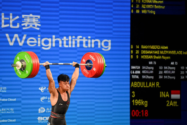 Lifter putra Indonesia Rahmat Erwin Abdullah melakukan angkatan clean and jerk pada final 73 kilogram Grup A Asian Games 2022 di Xiaoshan Sports Centre Gymnasium, Hangzhou, China, Selasa (3/10/2023). Foto: M Risyal Hidayat/Antara Foto 