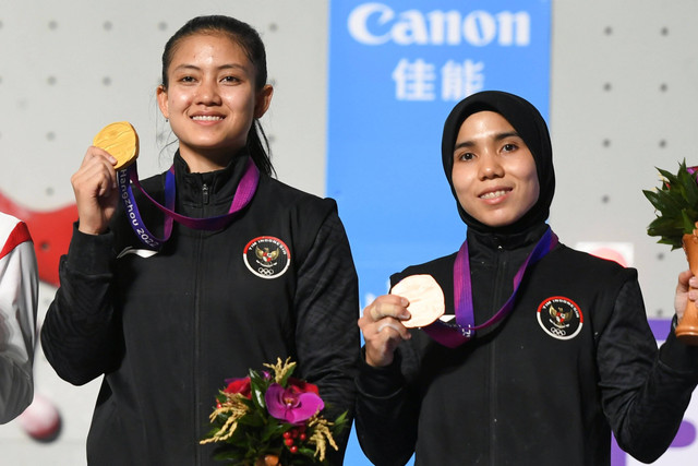 Atlet panjat tebing Indonesia Desak Made Rita Kusuma Dewi (kiri) dan Rajiah Sallsabillah menunjukkan medali nomor speed putri Asian Games 2022 di Shaoxing Keqiao Yangshan Sport Climbing Centre, Shaoxing, China, Selasa (3/10/2023). Foto: Hafidz Mubarak A/Antara Foto