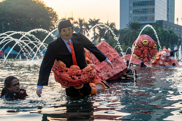 Sejumlah aktivis Greenpeace Indonesia membawa boneka gurita raksasa saat menggelar aksi kampanye tanpa oligarki di Bundaran Hotel Indonesia (HI), Jakarta, Jumat (6/10/2023). Foto: Muhammad Adimaja/ANTARA FOTO
