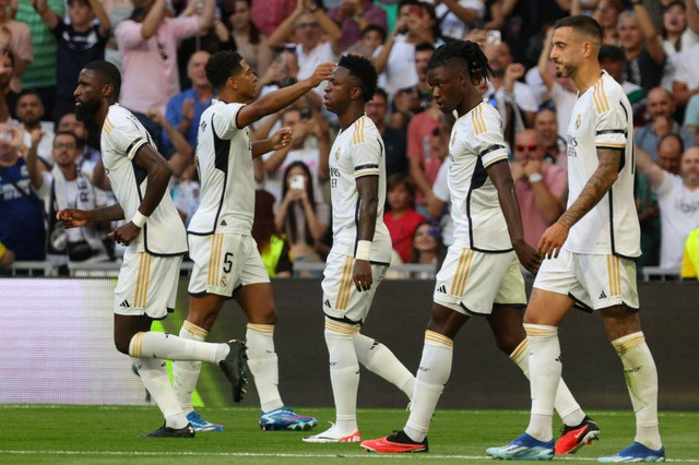 Para pemain Real Madrid merayakan gol pertama yang dicetak Jude Bellingham saat melawan Osasuna dalam pertandingan Liga Spanyol 2023/24 di Stadion Santiago Bernabeu, Madrid, Spanyol, pada Sabtu (7/10). Foto: Pierre-Philippe Marcou/AFP