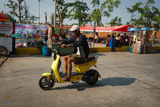Aktivitas warga menggunakan kendaraan listrik di kawasan Kalibaru, Cilincing, Jakarta Utara pada Minggu (8/10/2023). Foto: Iqbal Firdaus/kumparan