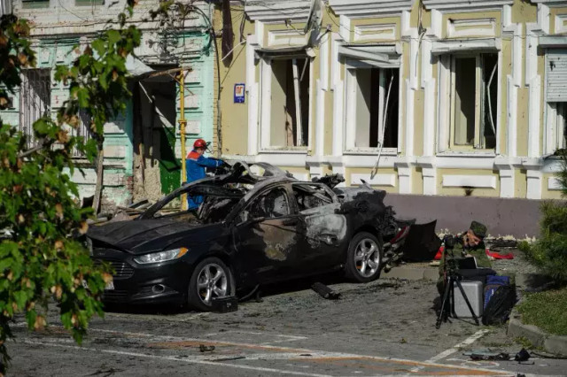 Seorang investigator memeriksa imbas serangan drone Ukraina yang jatuh di Rusia. Foto: AFP
