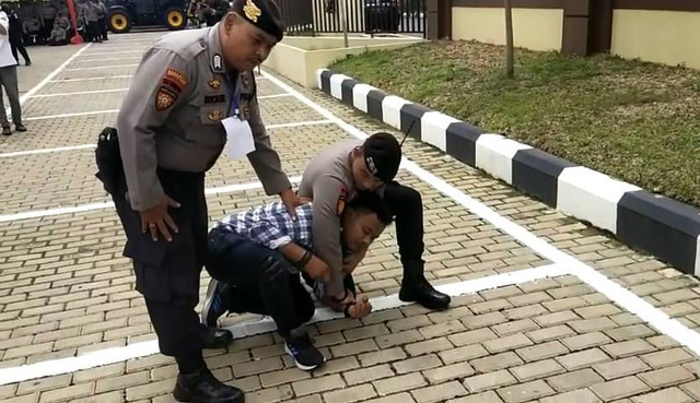 Polisi mengamankan pria yang ngamuk di TPS saat simulasi pemungutan suara. Foto: Dok. Hi!Pontianak