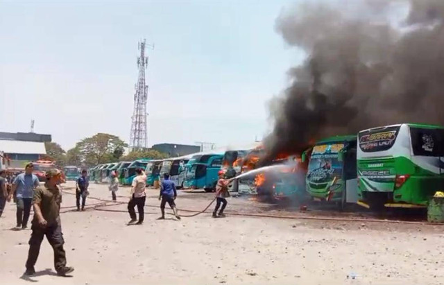 Petugas pemadam kebakaran saat melakukan upaya pemadaman kendaraan Bus yang terbakar di PO Bus Sahabat, Kabupaten Cirebon. Foto: Istimewa