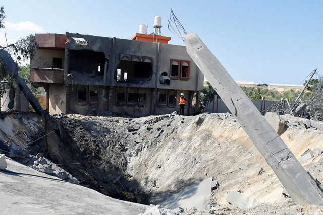 Pemandangan kawah yang terbentuk setelah serangan Israel di Khan Younis di Jalur Gaza selatan, Kamis (19/10/2023).  Foto: Ibraheem Abu Mustafa/REUTERS