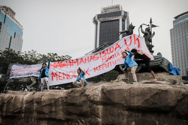 Mahasiswa memasang spanduk tuntutan aksi di Patung Kuda, Jakarta Pusat, Jumat (20/10/2023). Foto: Jamal Ramadhan/kumparan