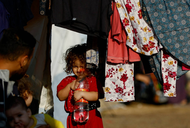 Seorang anak bermain di luar tenda kamp di sebuah pusat yang dikelola PBB, di Khan Younis di Jalur Gaza selatan, Jumat (20/10/2023). Foto: Ibraheem Abu Mustafa/REUTERS