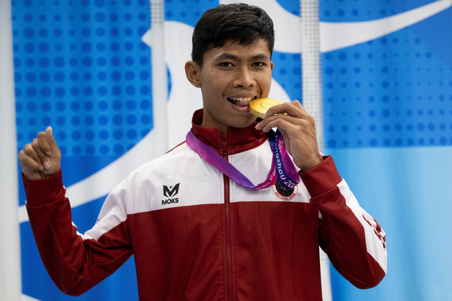 Pelari putra Indonesia Saptoyogo Purnomo berpose dengan medali emasnya usai upacara pengalungan medali nomor lari 400 meter T37 Asian Para Games 2022 di Hangzhou Olympic Sports Centre Stadium, Hangzhou, China, Senin (23/10/2023). Foto: NPC Indonesia/Josua Yulianto/Antara Foto