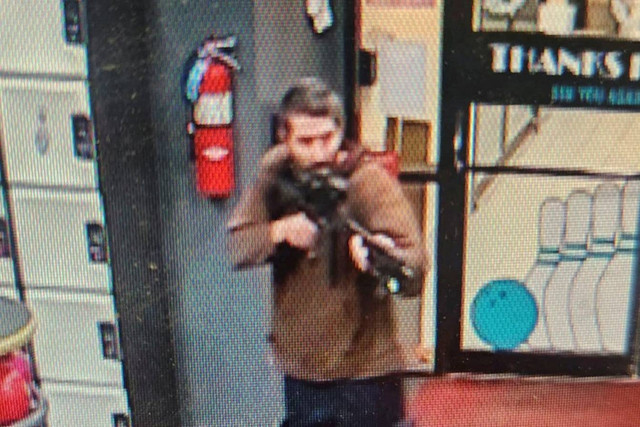 Seorang pria yang diidentifikasi sebagai tersangka oleh polisi menunjukkan apa yang tampak seperti senapan semi-otomatis, di Lewiston, Maine, AS, Rabu (25/10/2023). Foto: Androscoggin County Sheriff's Office/Handout via Reuters