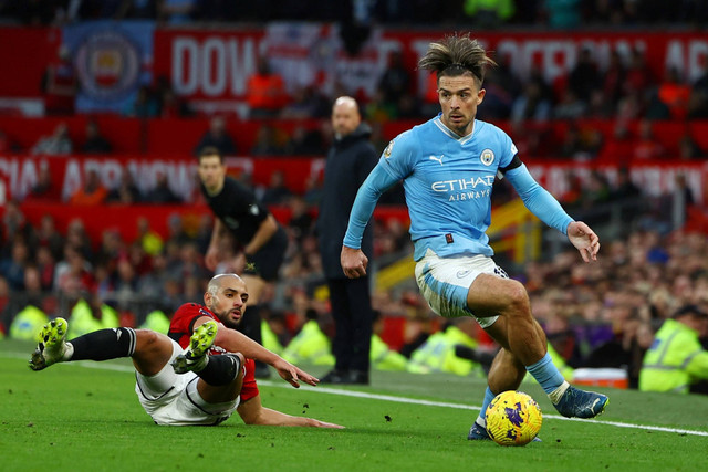 Pemain Manchester United Sofyan Amrabat berebut bola dengan pemain Manchester City Jack Grealish pada pertandingan Liga Inggris di Old Trafford, Manchester, Inggris, Minggu (29/10/2023). Foto: Molly Darlington/REUTERS