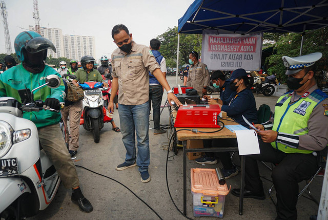 Petugas gabungan yang terdiri dari Ditlantas Polda Metro Jaya, Dinas Lingkungan Hidup DKI Jakarta dan Dinas Perhubungan DKI Jakarta menindak pengendara kendaraan bermotor di razia tilang uji emisi di kawasan Cakung, Jakarta, Rabu (1/11). Foto: Iqbal Firdaus/kumparan