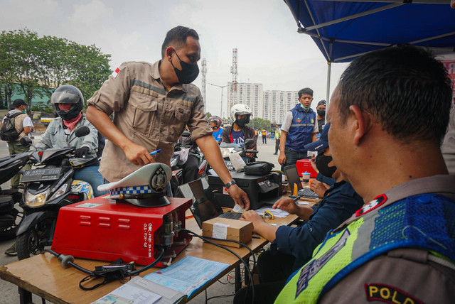 Petugas gabungan yang terdiri dari Ditlantas Polda Metro Jaya, Dinas Lingkungan Hidup DKI Jakarta dan Dinas Perhubungan DKI Jakarta menindak pengendara kendaraan bermotor di razia tilang uji emisi di kawasan Cakung, Jakarta, Rabu (1/11). Foto: Iqbal Firdaus/kumparan