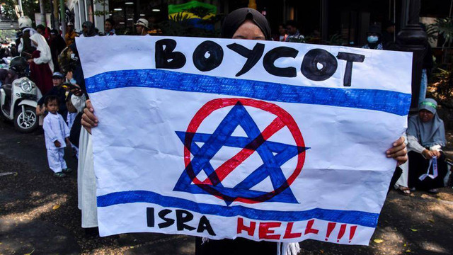 Sejumlah demonstran memegang poster boikot Israel dalam demonstrasi pro-Palestina di Bandung, Jawa Barat, pada 21 Oktober 2023.